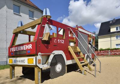 194 2024 © Lutz Ebhardt Eine große Spielzeugfeuerwehr steht auf einem Spielplatz.