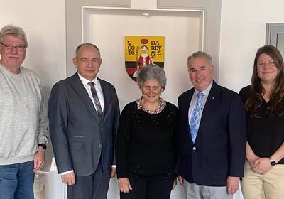 von links nach rechts: Matthias Wenzel, Oberbürgermeister Knut Kreuch, Carey Philpott, Mike Philpott, Julia Beez Gruppenbild vor Gotha-Wappen, öffnet größere Ansicht
