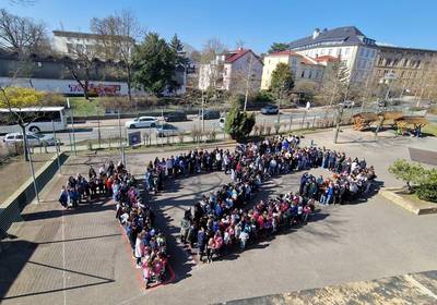 125-Jahre Reyherschule Kinder bilden auf einem Schulhof eine große Ziffer 125