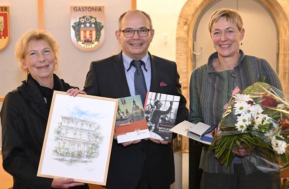 Cathleen Kempe, Oberbürgermeister Knut Kreuch und Gleichstellungbeauftrage Kerstin Tornow halten Bücher und Blumen.