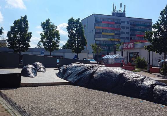 Die Sanierung des Laufbrunnens am Coburger Platz ist nun abgeschlossen. Laufbrunnen am Coburger Platz mit einem großen Wohnblock im Hintergrund.