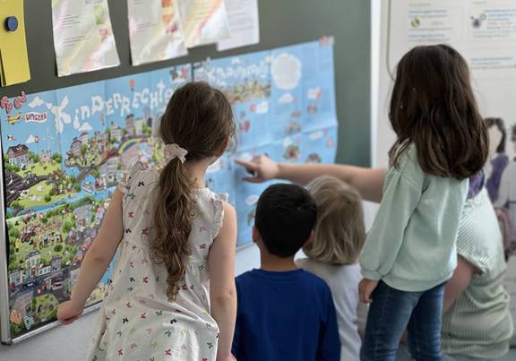 Wanderausstellung zum Thema Kinderschutz im Kindergarten "Sonnenblume" Kinder betrachten eine bunte